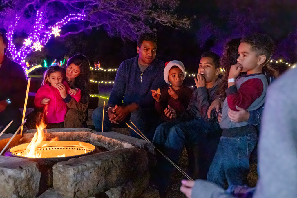 A family sitting around a campfire roasting marshmallows and enjoying the holiday atmosphere at Christmas at the Caverns, Natural Bridge Caverns